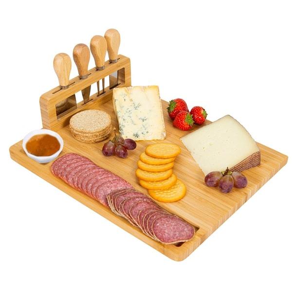 Charcuterie board with salami, crackers, cheese, grapes, strawberries, and dipping sauce.