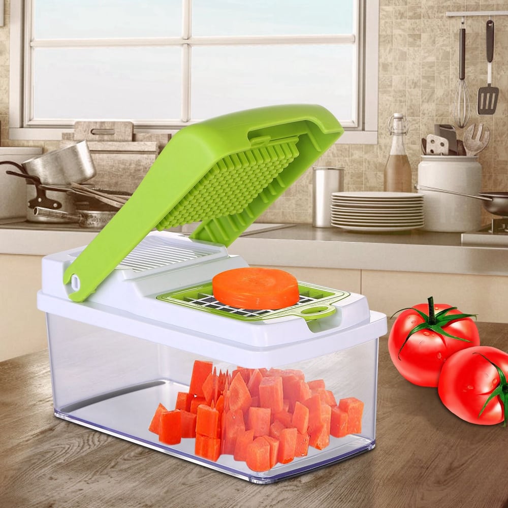 Vegetable dicer in kitchen chopping carrots with tomatoes nearby