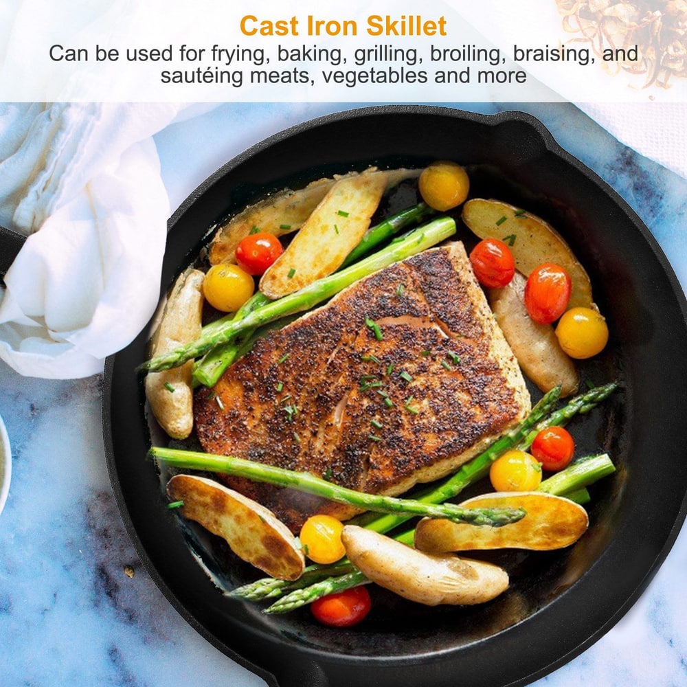 Cooked fish fillet with potatoes, asparagus, and cherry tomatoes in a cast iron skillet.