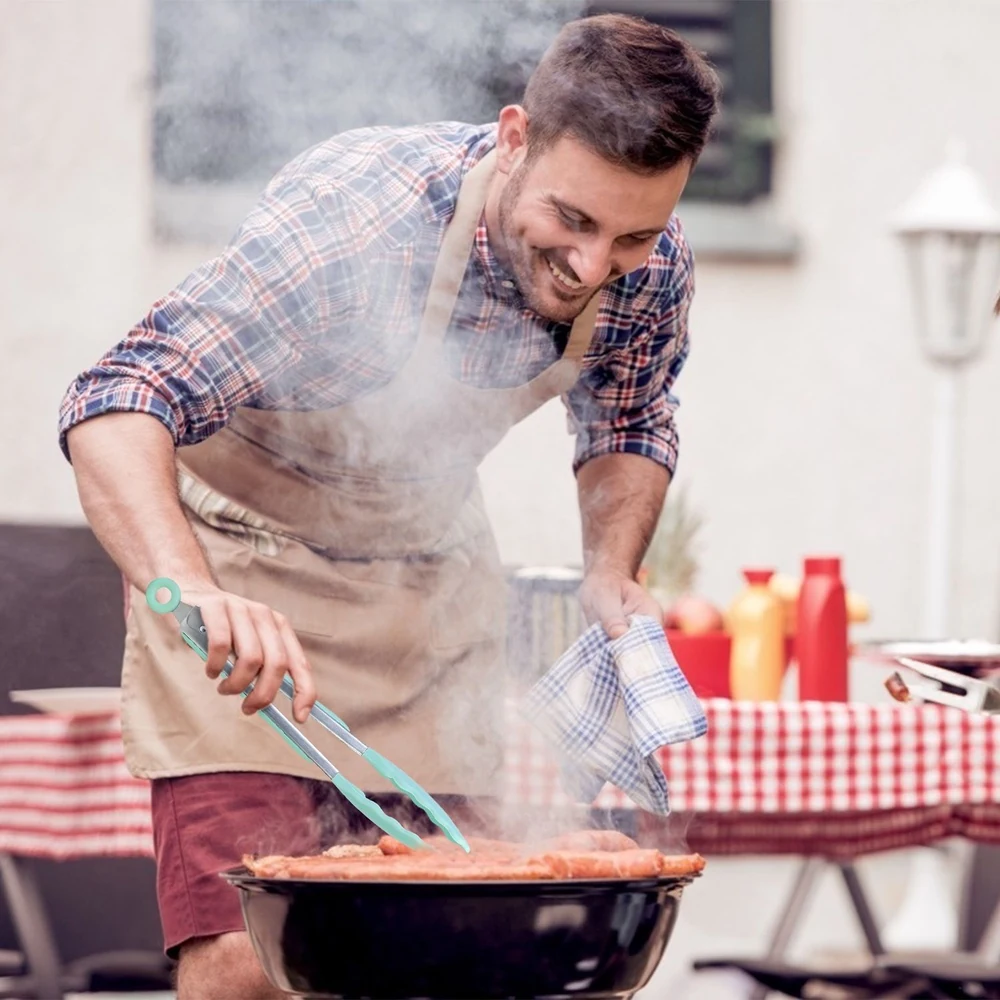 Man grilling meat on barbecue in backyard with condiments in the background.