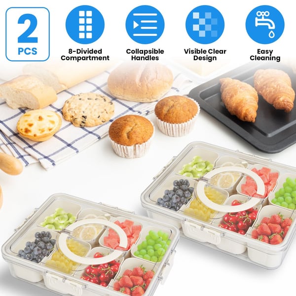 Two divided food storage containers with handles holding assorted fruits, surrounded by baked goods and kitchen utensils.