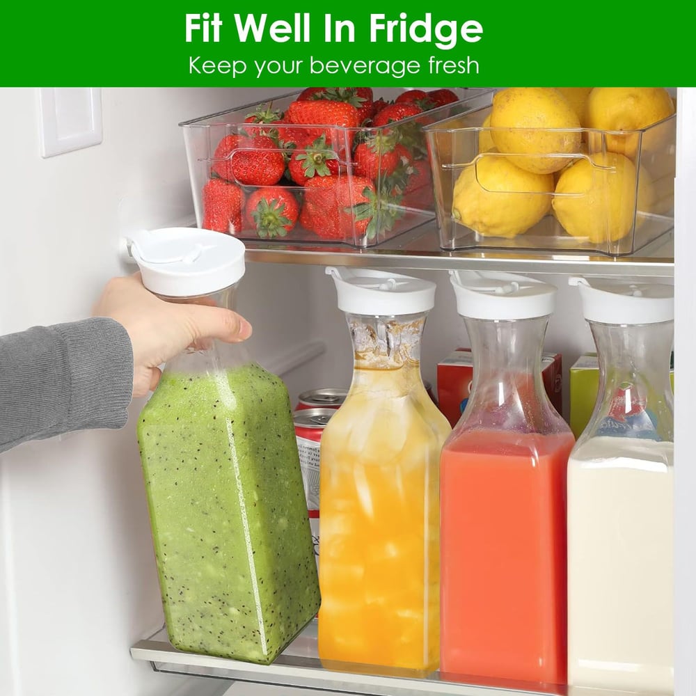 Hand placing a bottle of green smoothie in a refrigerator with neatly arranged beverages and fresh fruits