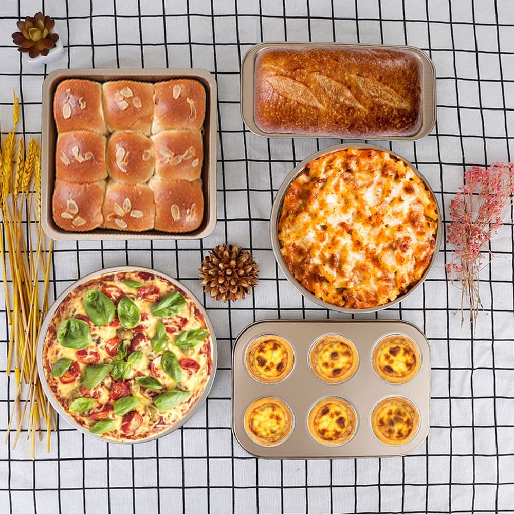 Assorted baked goods including dinner rolls, loaf bread, lasagna, pizza, and egg tarts on a grid-pattern tablecloth.