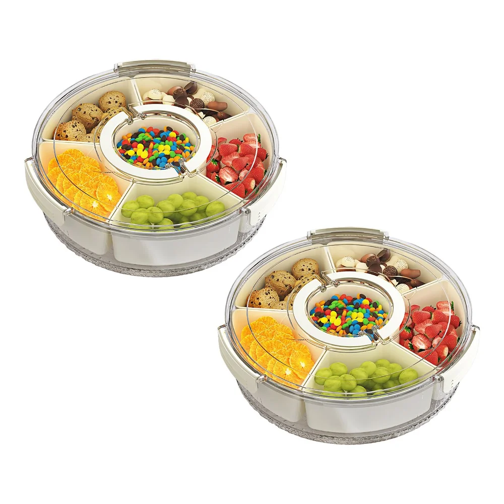 Two circular plastic snack trays with sections containing oranges, grapes, strawberries, cookies, chocolates, and colorful candies